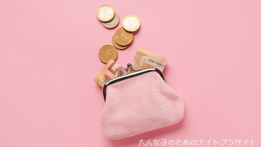 ピンクの財布からお金がこぼれている