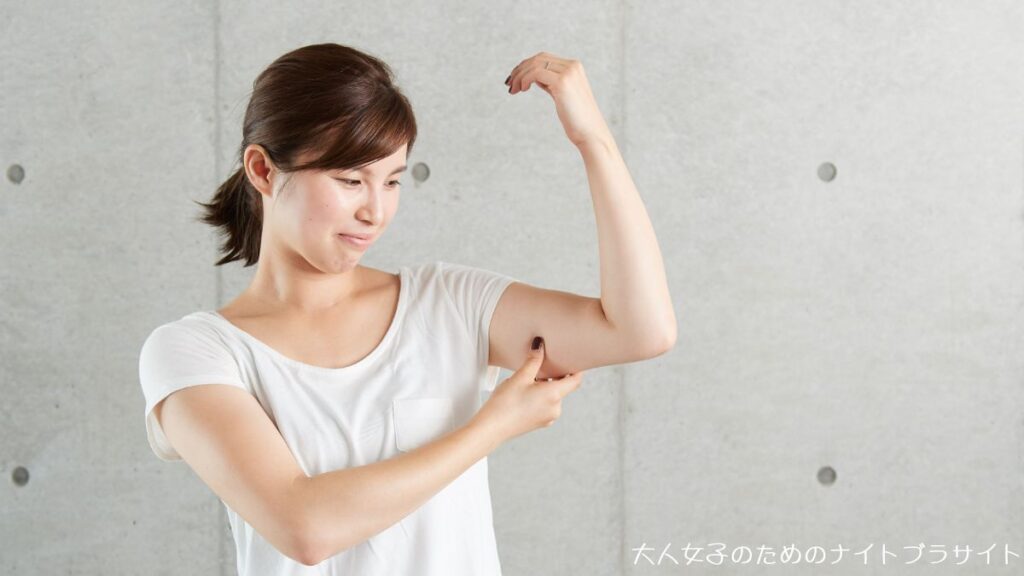 二の腕を揉みながら困った顔をする女性